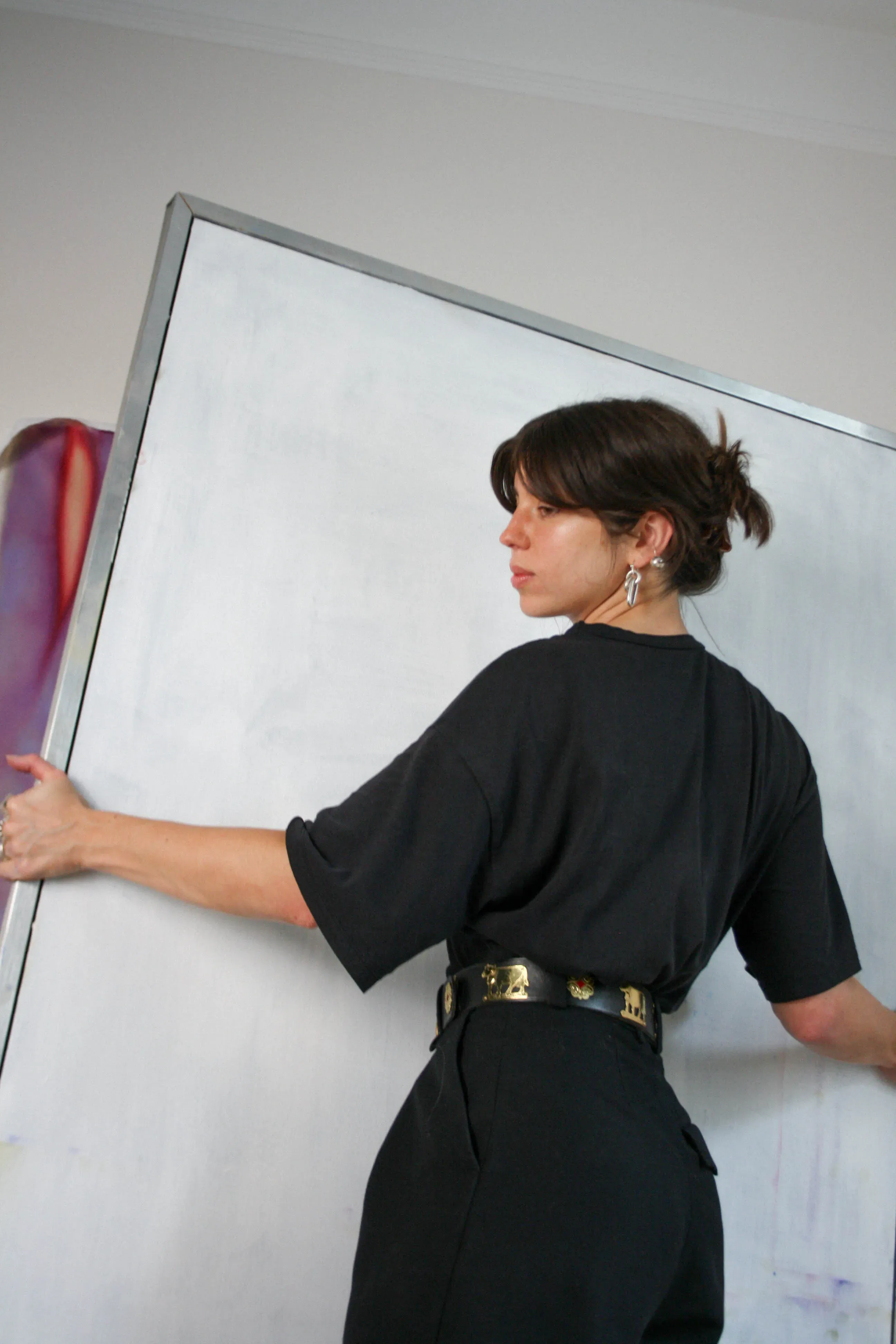 Lorena Lucek dressed in black clothes holding a large white frame